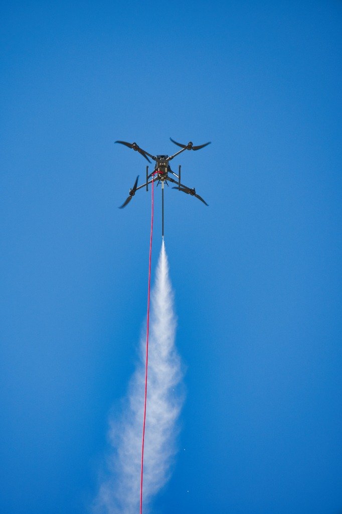Dron en vuelo con sistema de pulverización y limpieza